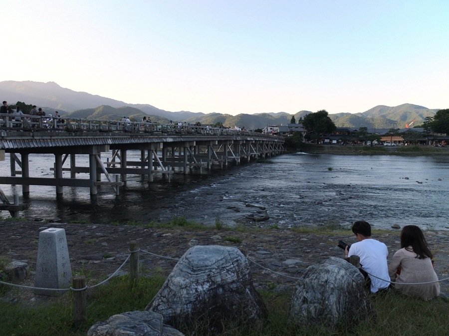 Tourists relax by one of the rivers dissecting Kyoto