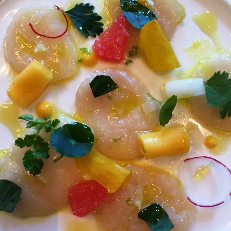 Marinated pacific scallop carpaccio with sea urchin, mango, and ginger dressing