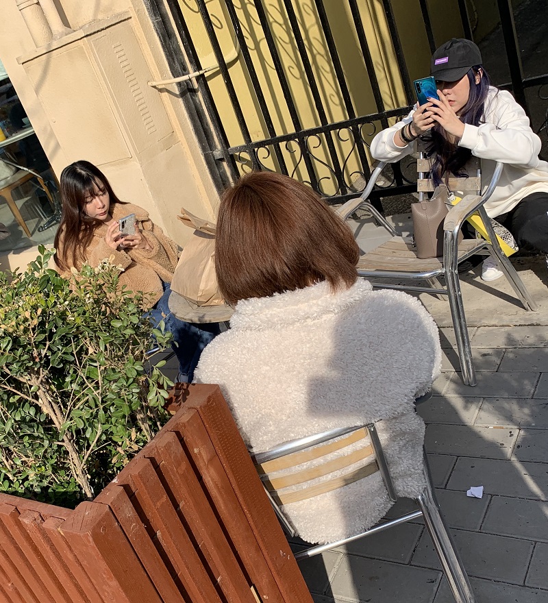 Da Giuliano patrons check the latest on the outbreak while enjoying some sun