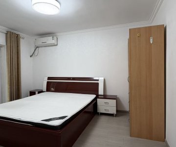 "Second bedroom with large wardrobe, bedside cabinets and floor-length curtains