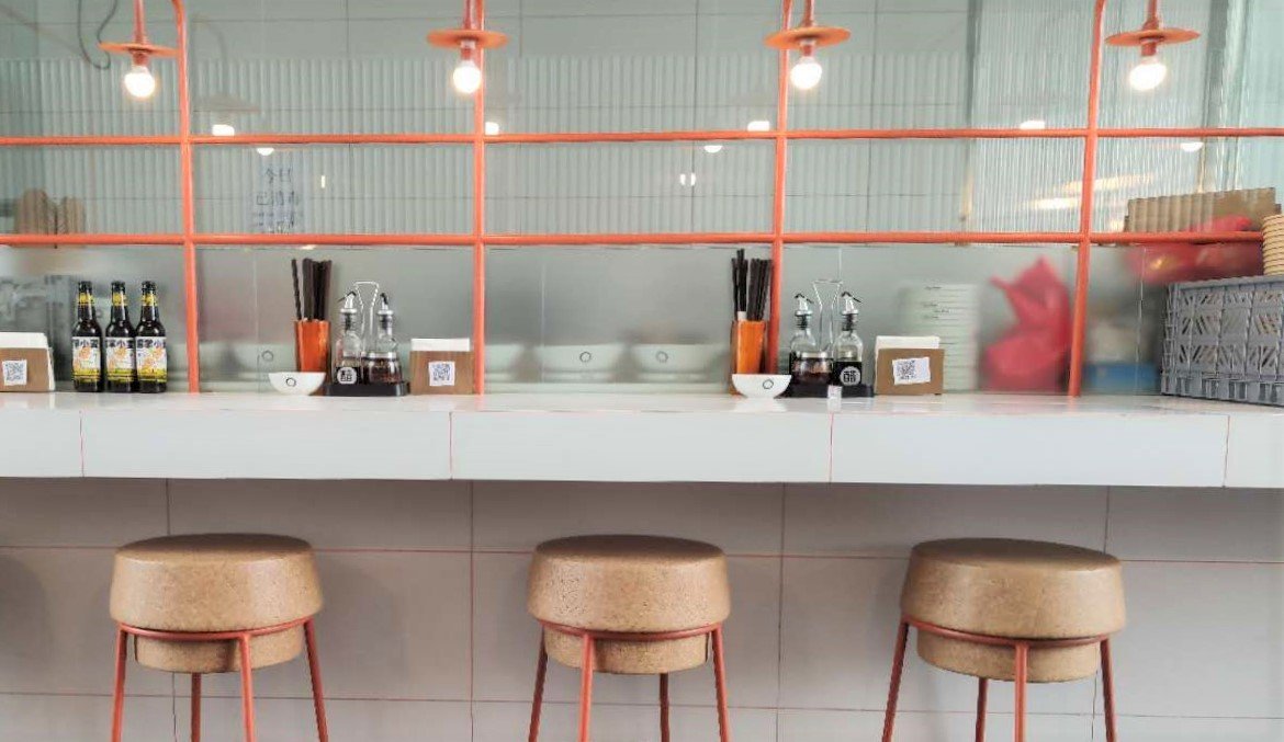 Cork stools, sleek white surfaces, and bar and booth seating give the humble restaurant a modern aesthetic